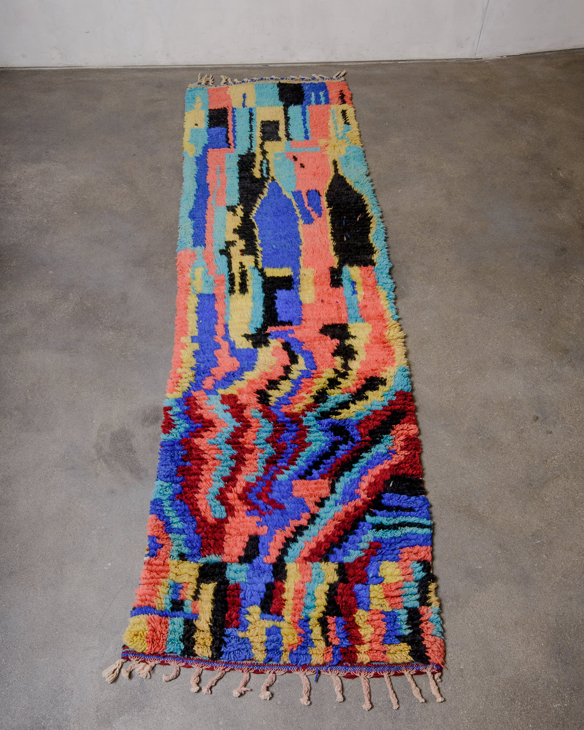 Berberlin vintage runner rug made of brightly coloured wool, laying flat on concrete floor.